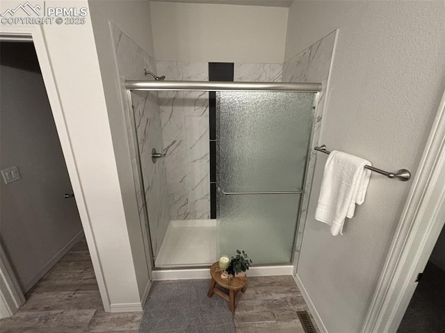 bathroom featuring wood-type flooring and walk in shower