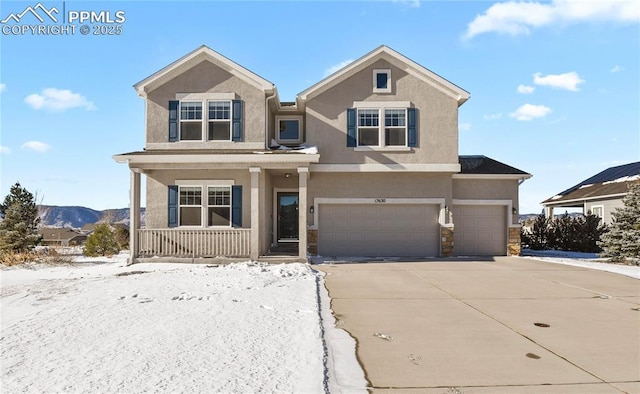 view of front of home featuring a garage, a mountain view, and covered porch