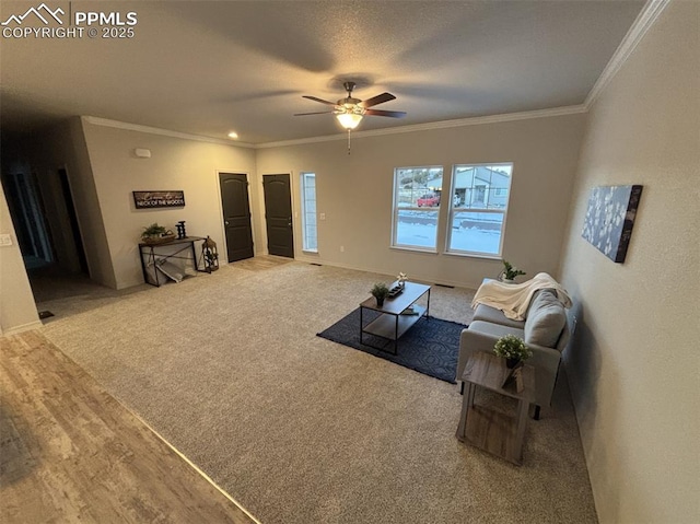 living room featuring carpet flooring, ceiling fan, ornamental molding, and a textured ceiling