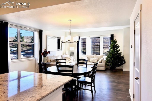 dining room featuring dark hardwood / wood-style flooring, a textured ceiling, and a chandelier