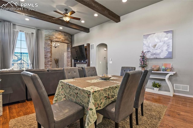 dining space featuring ceiling fan, hardwood / wood-style floors, and beamed ceiling