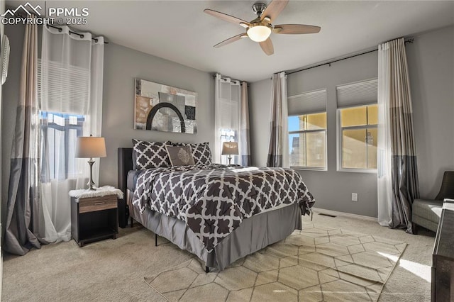 carpeted bedroom with ceiling fan and multiple windows