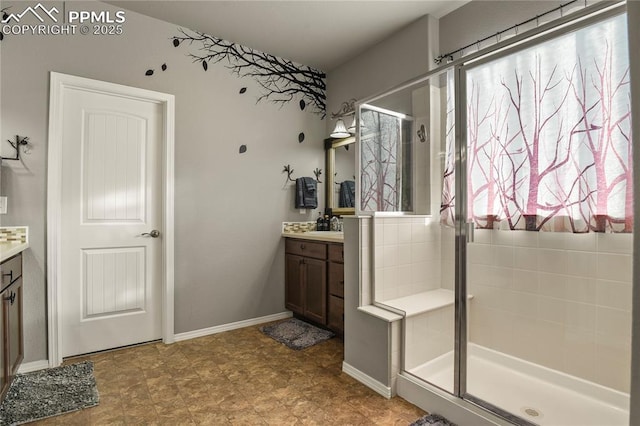 bathroom featuring a shower with door and vanity