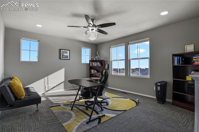 carpeted office space featuring ceiling fan