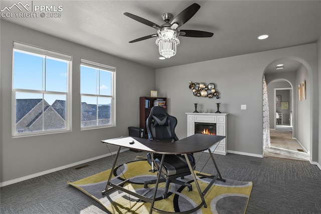 carpeted office featuring ceiling fan