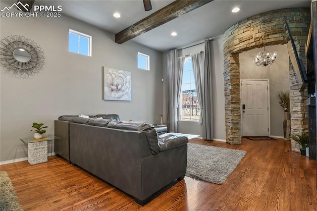 living room featuring a chandelier, beam ceiling, and wood-type flooring