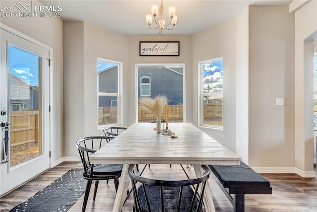 dining area featuring hardwood / wood-style flooring, an inviting chandelier, and a wealth of natural light