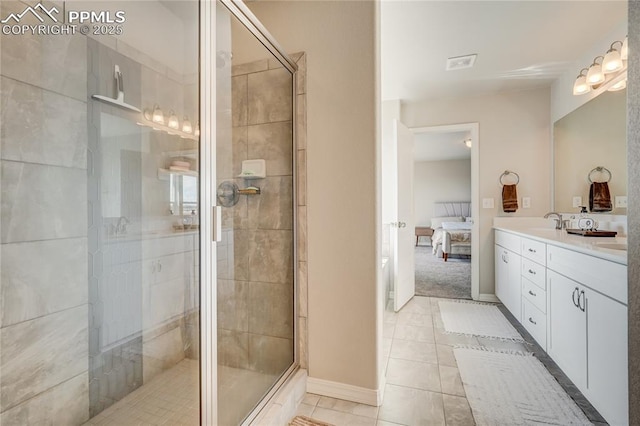 bathroom with tile patterned floors, vanity, and a shower with door