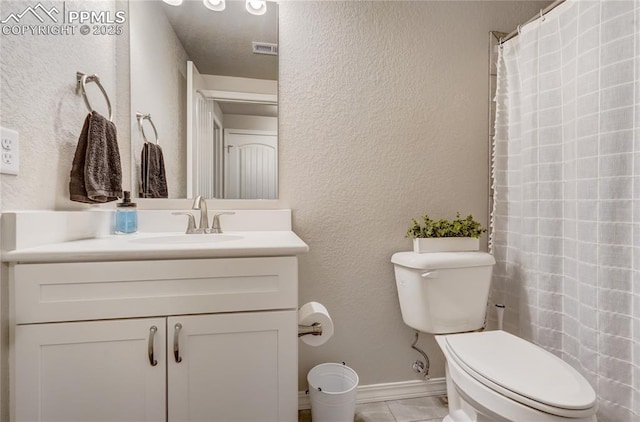 bathroom featuring tile patterned flooring, vanity, and toilet