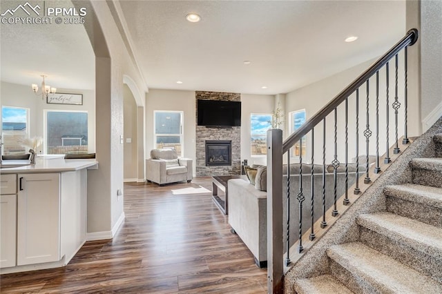 living room featuring dark hardwood / wood-style floors, a fireplace, and an inviting chandelier