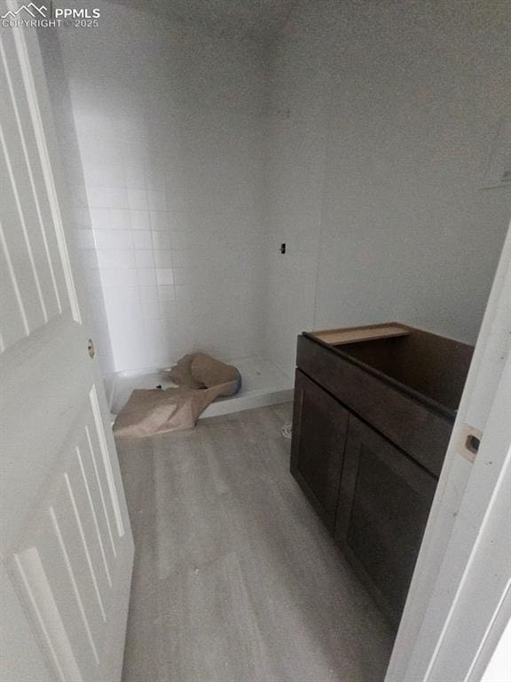 bathroom featuring a shower and wood-type flooring