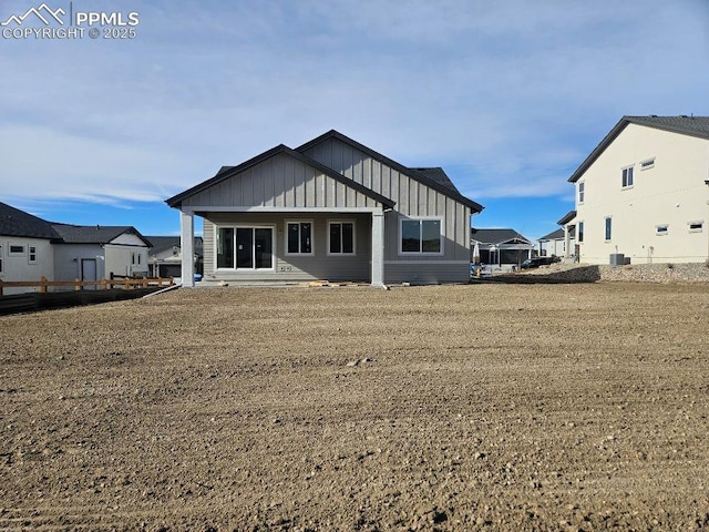 rear view of property featuring central AC unit and a yard