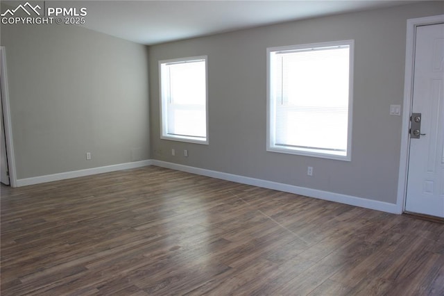 unfurnished room featuring dark hardwood / wood-style flooring and a wealth of natural light