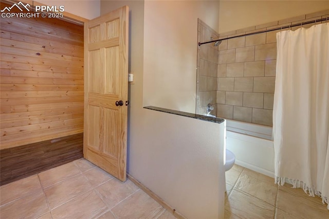 bathroom featuring toilet and shower / bathtub combination with curtain