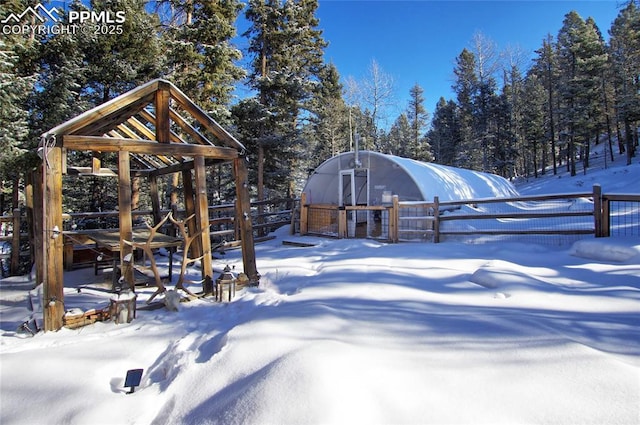 snowy yard featuring an outbuilding