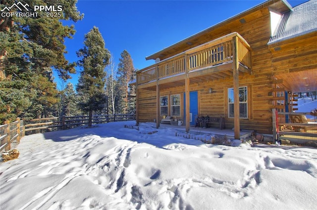 snow covered property featuring a balcony