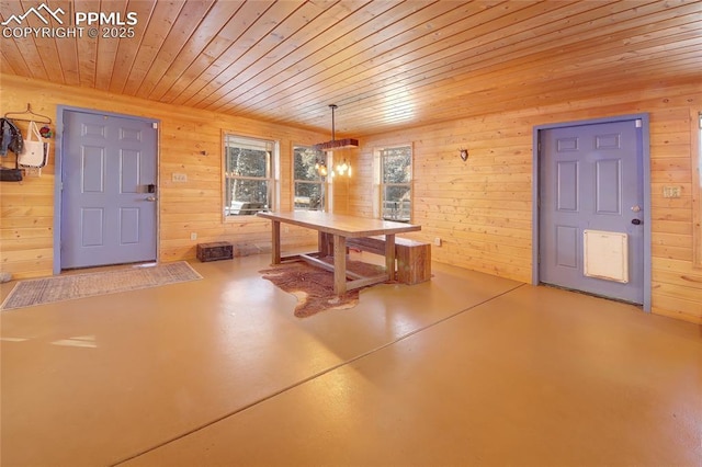 unfurnished dining area featuring wooden walls, concrete floors, a chandelier, and wooden ceiling