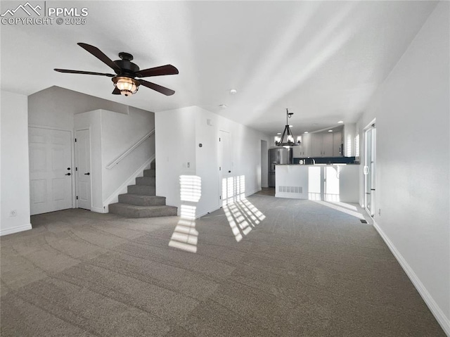7707 Orange Sunset Dr, Colorado Springs, CO 80922 - unfurnished living room featuring carpet flooring and ceiling fan with notable chandelier