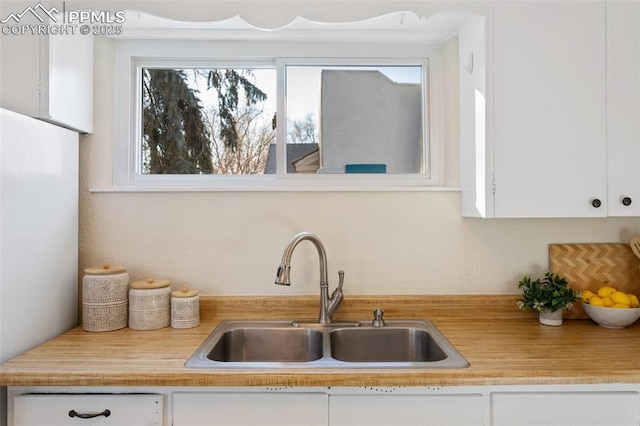 kitchen featuring white cabinets and sink