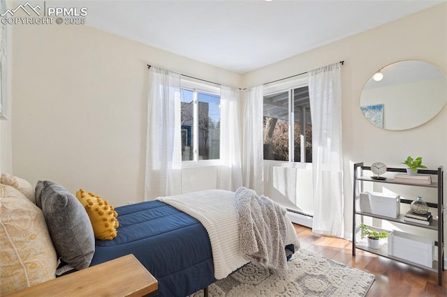 bedroom with baseboard heating and dark wood-type flooring