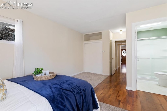 bedroom with dark wood-type flooring and ensuite bathroom