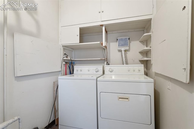 washroom featuring cabinets and washing machine and clothes dryer