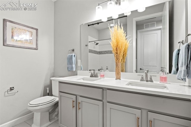 bathroom featuring tile patterned flooring, toilet, vanity, and walk in shower