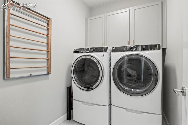 washroom featuring cabinets and washer and clothes dryer