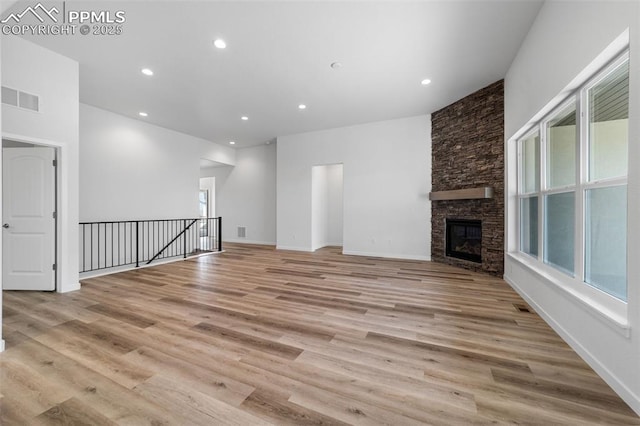 unfurnished living room with a fireplace and light wood-type flooring