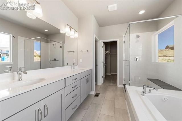 bathroom featuring tile patterned flooring, vanity, and shower with separate bathtub