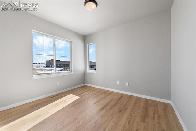 empty room with light hardwood / wood-style flooring