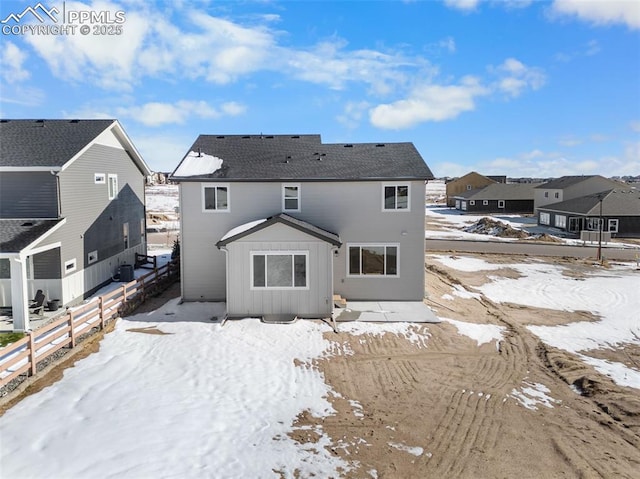 view of snow covered rear of property