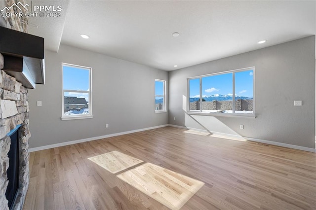 unfurnished living room with a fireplace and light wood-type flooring