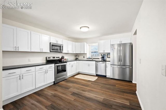 kitchen with dark hardwood / wood-style flooring, white cabinets, stainless steel appliances, and sink