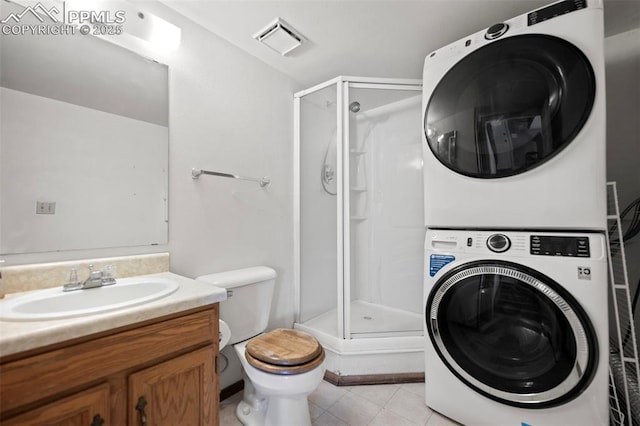 laundry area featuring stacked washer / dryer, sink, and light tile patterned floors