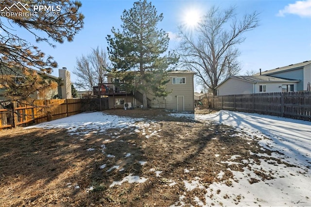 snow covered rear of property featuring a deck