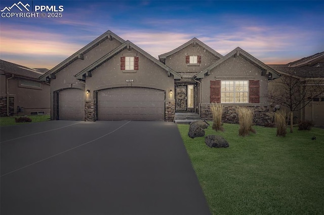 french provincial home with a lawn and a garage