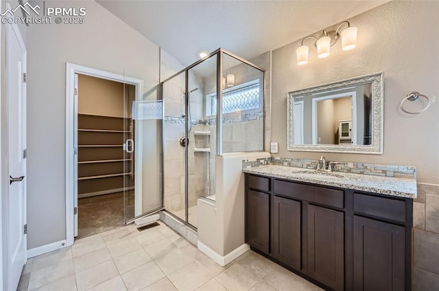 bathroom with vanity, a shower with door, and tile patterned flooring