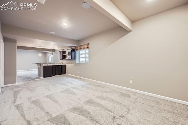 interior space featuring carpet flooring, a kitchen bar, kitchen peninsula, hanging light fixtures, and beam ceiling