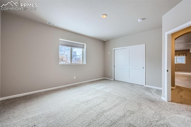 unfurnished bedroom with carpet floors and multiple windows