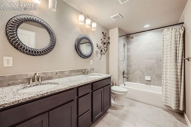 full bathroom with shower / tub combo, tile patterned flooring, toilet, vanity, and a textured ceiling