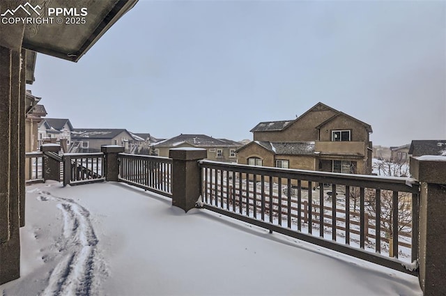 view of snow covered back of property