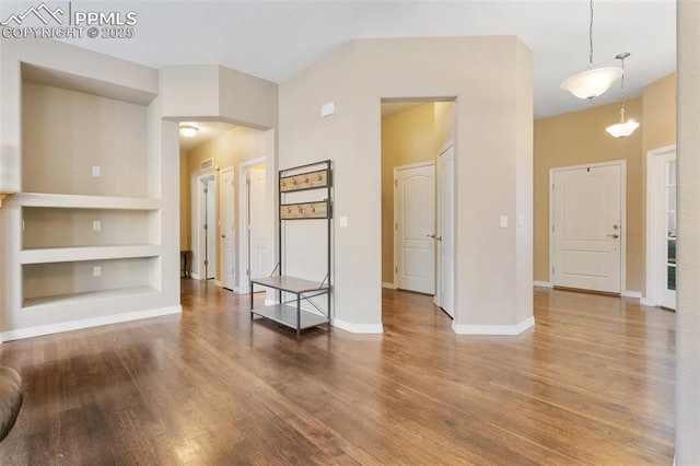 unfurnished living room with hardwood / wood-style flooring and built in features