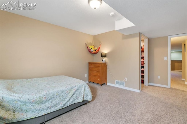 bedroom with carpet flooring, a walk in closet, and a closet