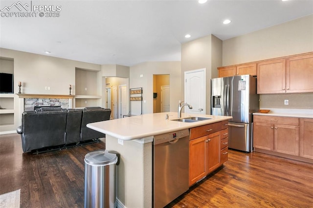 kitchen featuring dark hardwood / wood-style floors, sink, appliances with stainless steel finishes, and an island with sink