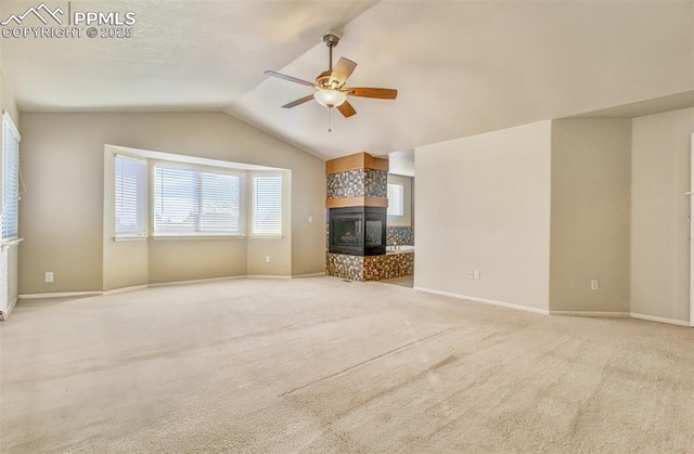 unfurnished living room featuring ceiling fan, light colored carpet, vaulted ceiling, and a fireplace