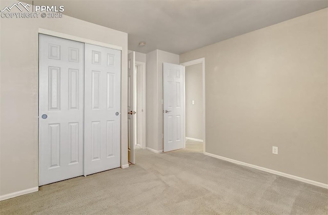 unfurnished bedroom with light colored carpet and a closet