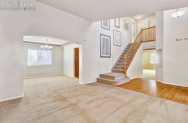 empty room featuring a chandelier and carpet flooring