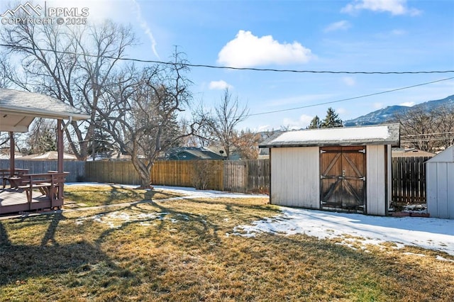 view of yard featuring a deck with mountain view and a storage unit