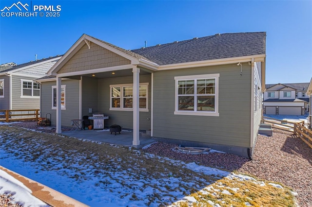 snow covered rear of property with a patio